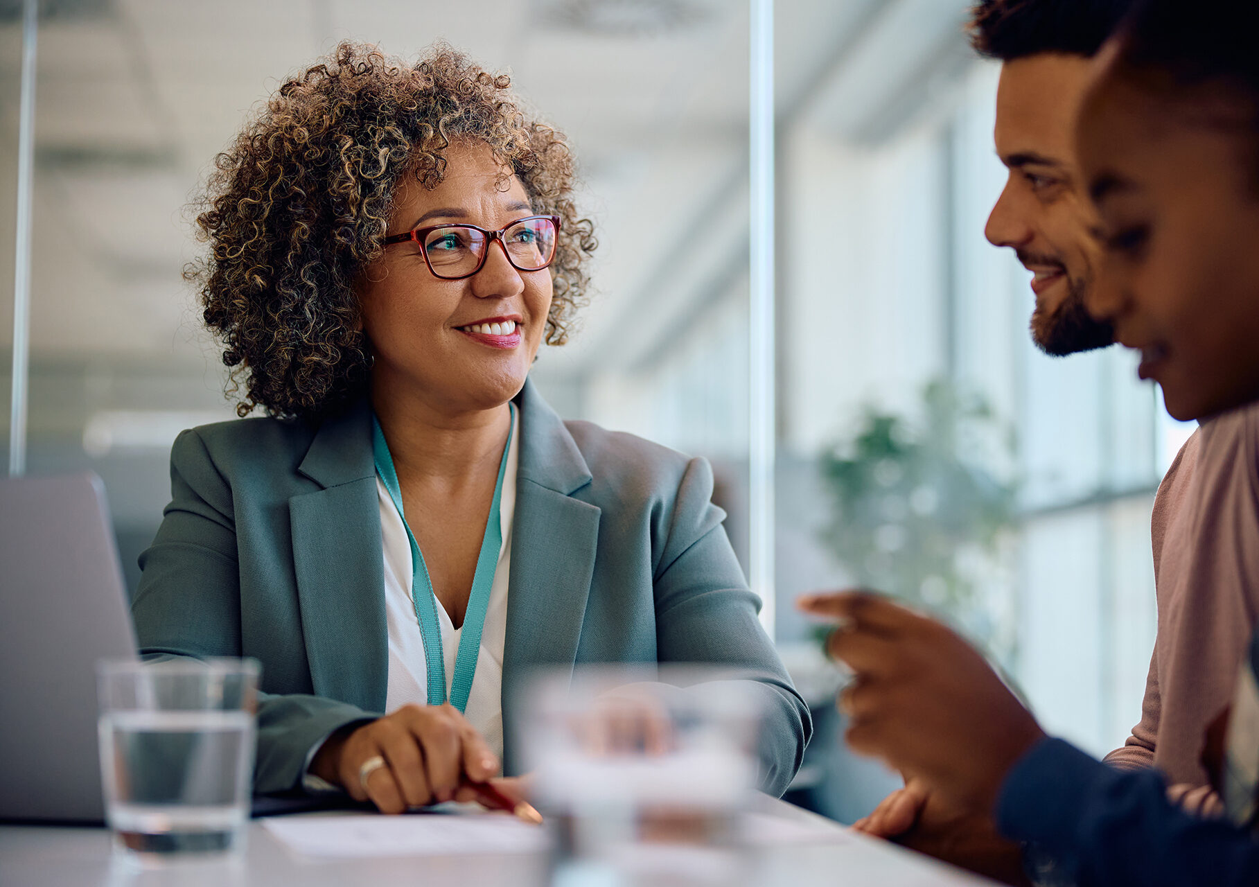 Happy insurance agent offering an agreement to young couple during a meeting in the office.